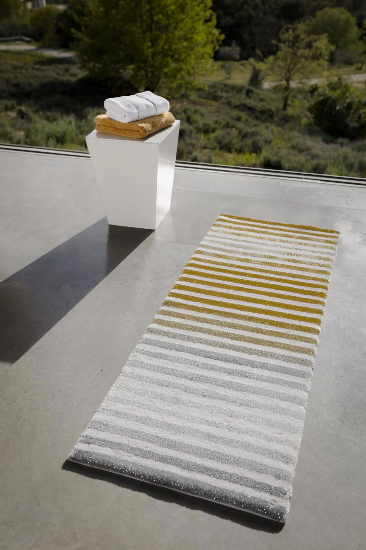 The A&H Barns Bath Rug is a striped runner/dual vanity rug. Colours include 100 White, 103 Ivory, 840 Gold, 930 Perle and 992 Platinum