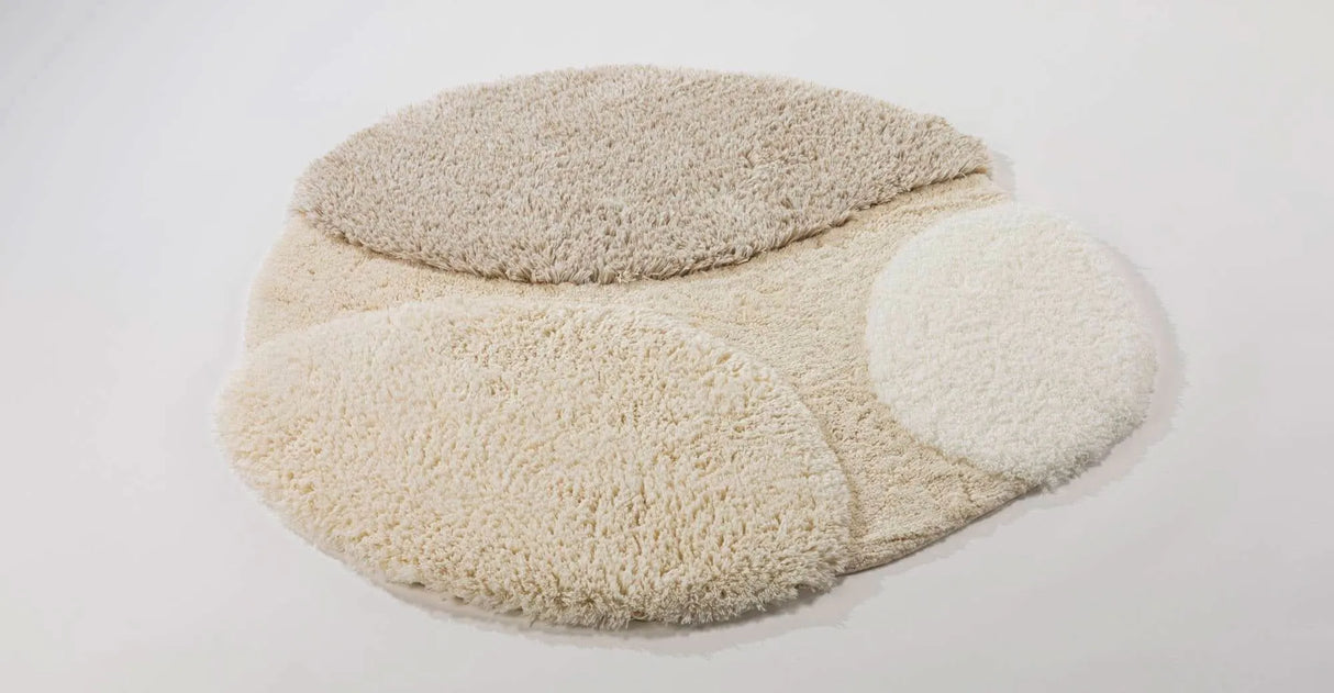 A&H Cordeira Bath Rugs feature white, ecru, ivory and linen tones and are available in two unique shapes and sizes