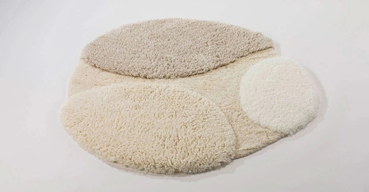 A&H Cordeira Bath Rugs feature white, ecru, ivory and linen tones and are available in two unique shapes and sizes