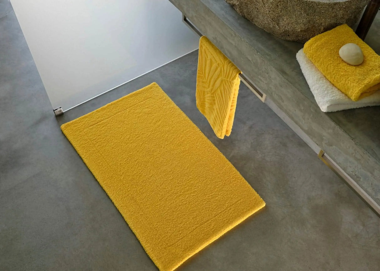 A&H Double Tub Mat (floor) in 830 Banane. A&H Super Pile Towels (on vanity) in 830 Banane and 100 White. Hanging towel is discontinued