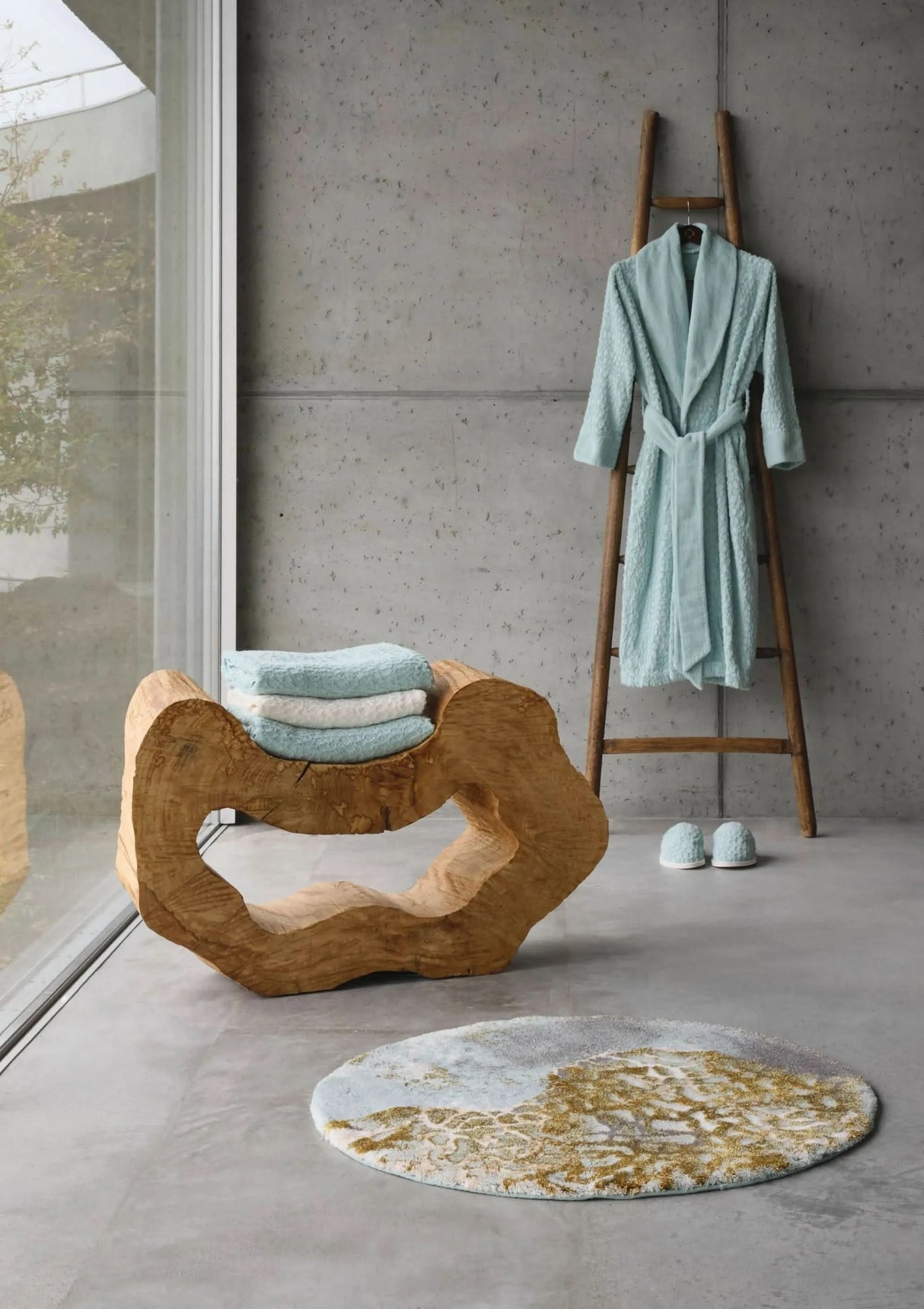 A&H Dune Bath Rug, 33" diameter. A&H Lodge Towels in 235 Ice & 103 Ivory on wood sculpture. A&H Lodge Robe & Slippers in 235 Ice