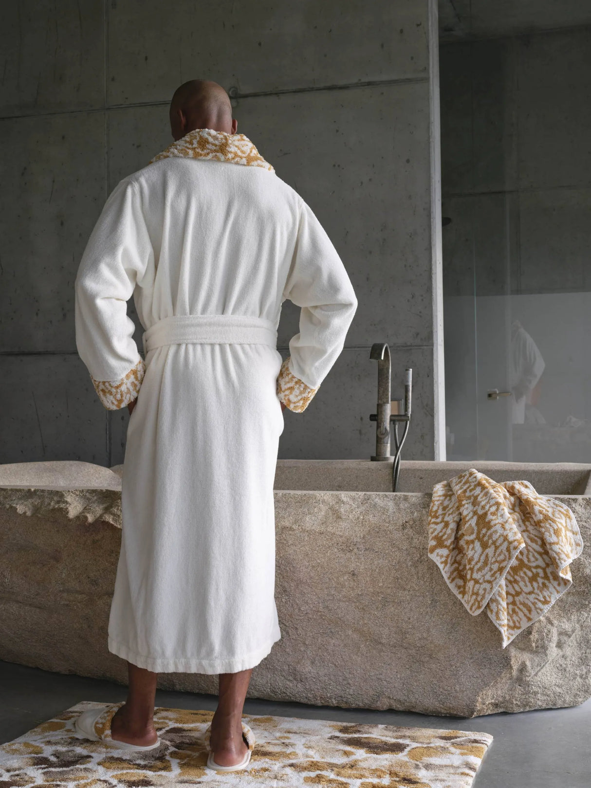 A&H Sauvage Towel in 840 Gold (edge of tub). A&H Sauvage Robe & Slippers in 840 Gold. A&H Gigi Rug in 840 Gold