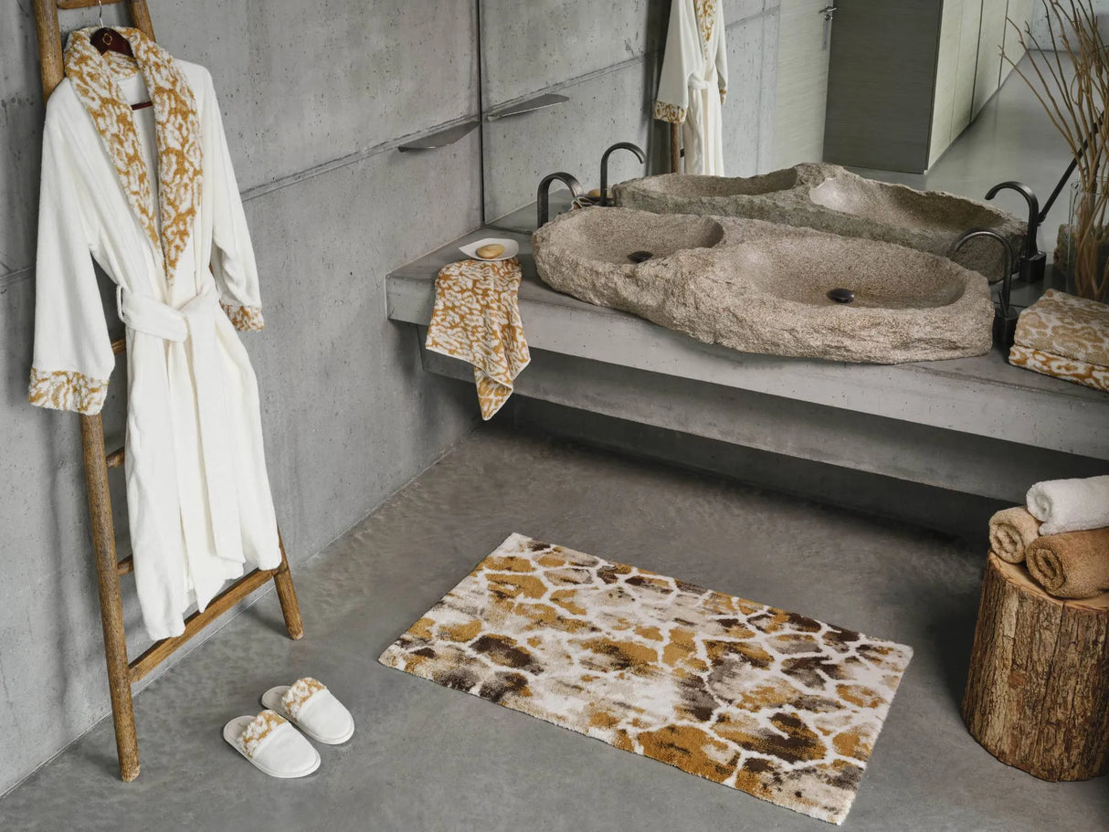 A&H Sauvage Towel in 840 Gold (left vanity), 714 Sand on 840 Gold (right vanity). A&H Sauvage Robe & Slippers in 840 Gold. A&H Gigi Rug in 840 Gold