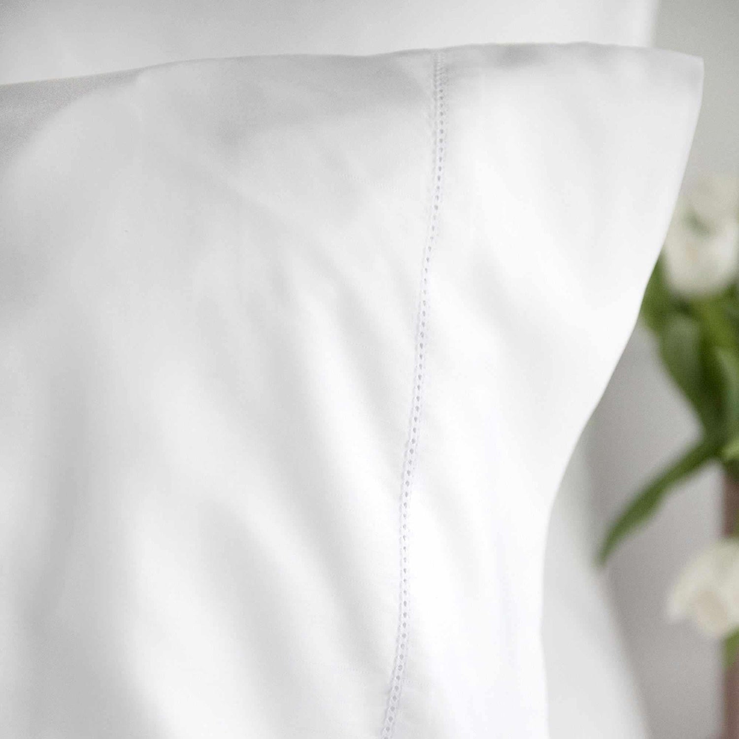 Cora is a gorgeous 100% MicroModal sateen in solid white. Close-up of the hemstitch finish on flat sheets and pillowcases