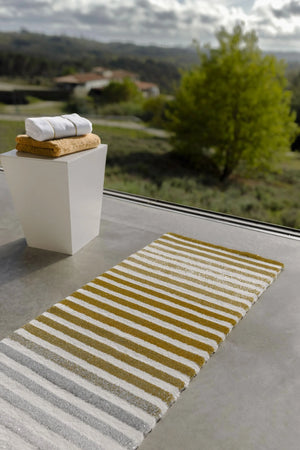 The A&H Barns Bath Rug is a striped runner/dual vanity rug. Colours include 100 White, 103 Ivory, 840 Gold, 930 Perle and 992 Platinum