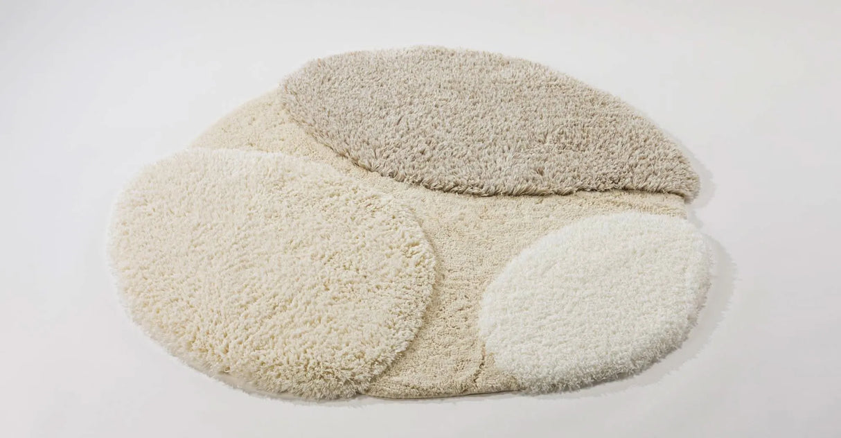 A&H Cordeira Bath Rugs feature white, ecru, ivory and linen tones and are available in two unique shapes and sizes