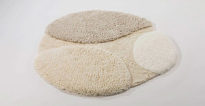 A&H Cordeira Bath Rugs feature white, ecru, ivory and linen tones and are available in two unique shapes and sizes
