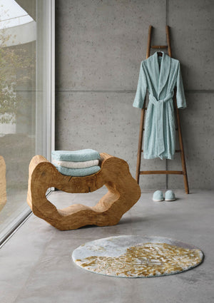 A&H Dune Bath Rug, 33" diameter. A&H Lodge Towels in 235 Ice & 103 Ivory on wood sculpture. A&H Lodge Robe & Slippers in 235 Ice