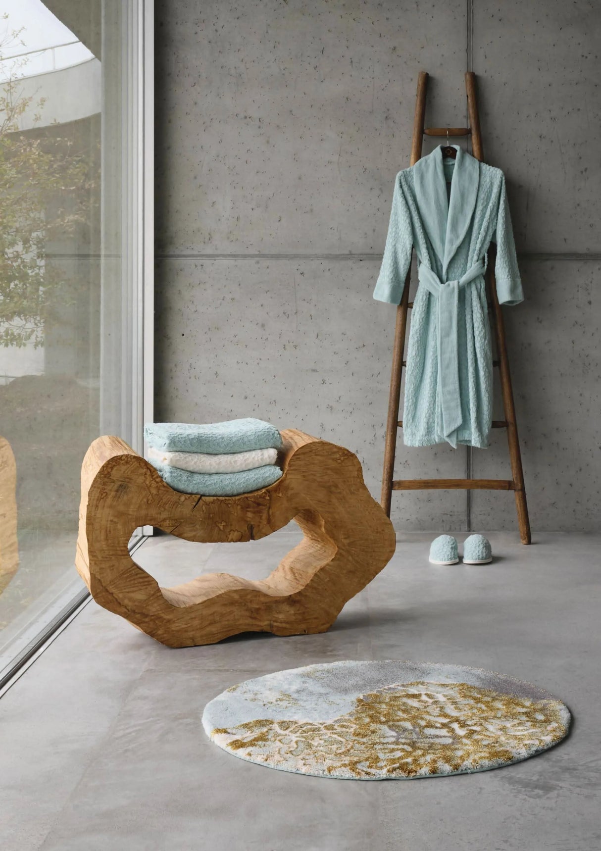 A&H Dune Bath Rug, 33" diameter. A&H Lodge Towels in 235 Ice & 103 Ivory on wood sculpture. A&H Lodge Robe & Slippers in 235 Ice