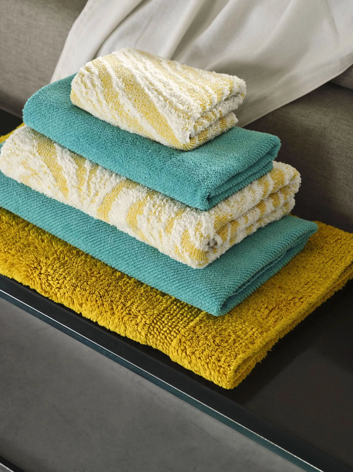 A&H Towels, top-to-bottom: Fogo in 278 Yuzu, Twill in 302 Lagoon, Fogo, Twill, and bottom: A&H Reversible Rug in 278 Yuzu