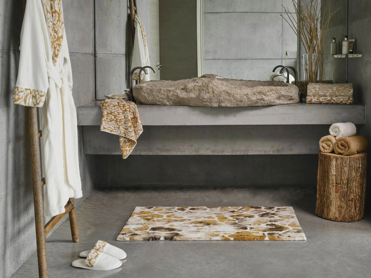 A&H Sauvage Towel in 840 Gold (left vanity), 714 Sand on 840 Gold (right vanity). A&H Sauvage Robe & Slippers in 840 Gold. A&H Gigi Rug in 840 Gold