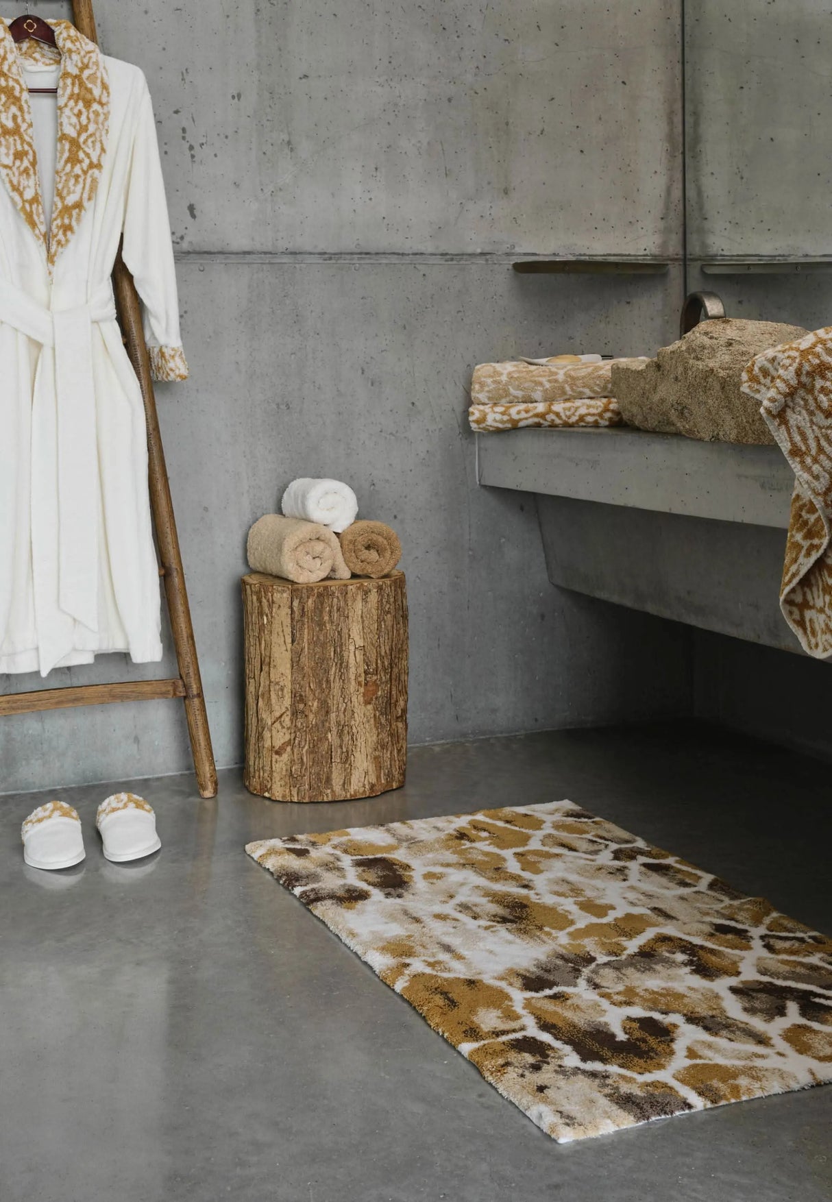 A&H Gigi Rug in 840 Gold. A&H Sauvage Towels in 714 Sand on 840 Gold (left vanity). A&H Sauvage Robe & Slippers in 840 Gold. A&H Super Pile Towels (left-to-right) in 714 Sand, 100 White and 840 Gold