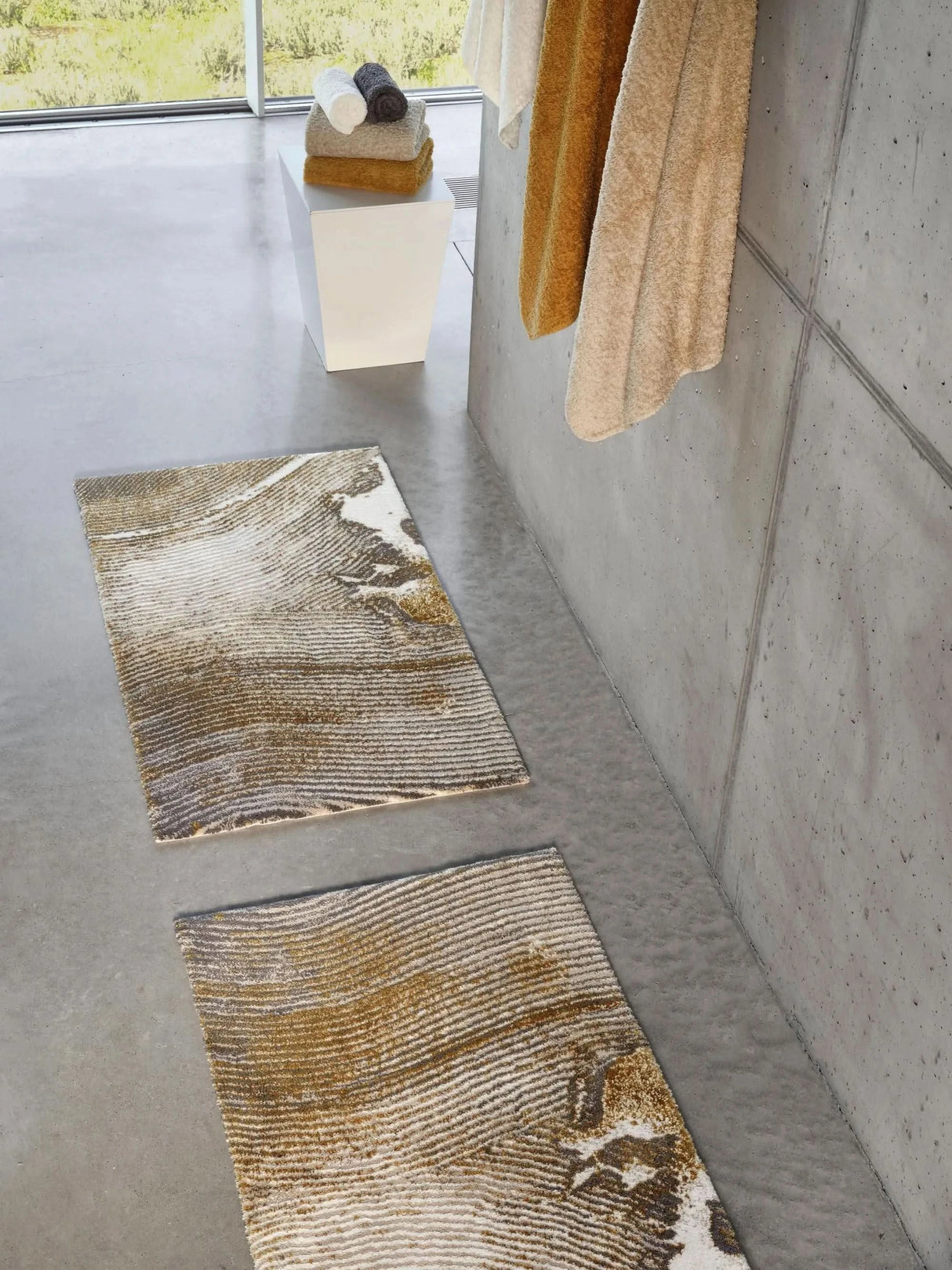 The A&H Lana Bath Rug features a striking striped design in gold, ivory and grey tones