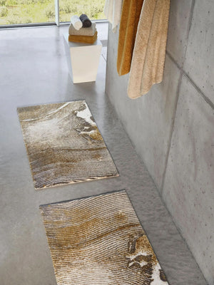 The A&H Lana Bath Rug features a striking striped design in gold, ivory and grey tones