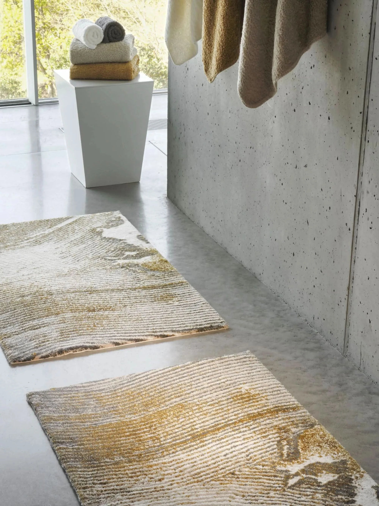 The A&H Lana Bath Rug features a striking striped design in gold, ivory and grey tones