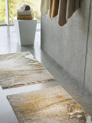 The A&H Lana Bath Rug features a striking striped design in gold, ivory and grey tones