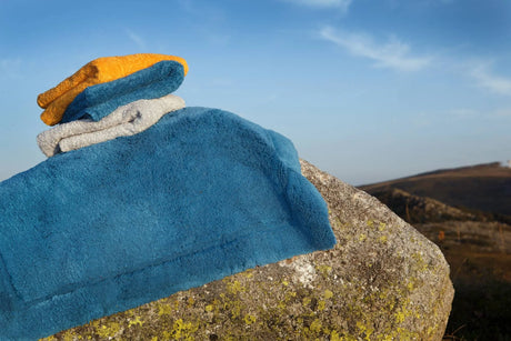 A&H Must Rug in 336 Ocean. A&H Super Pile Towels (top-to-bottom) in 870 Curcuma, 336 Ocean and 992 Platinum