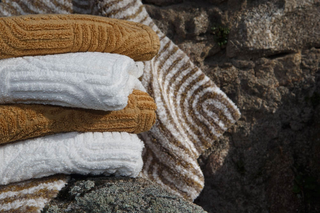 A&H Olly Towels in 103 Ivory & 840 Gold. A&H Petal Bath Rug in 770 Linen