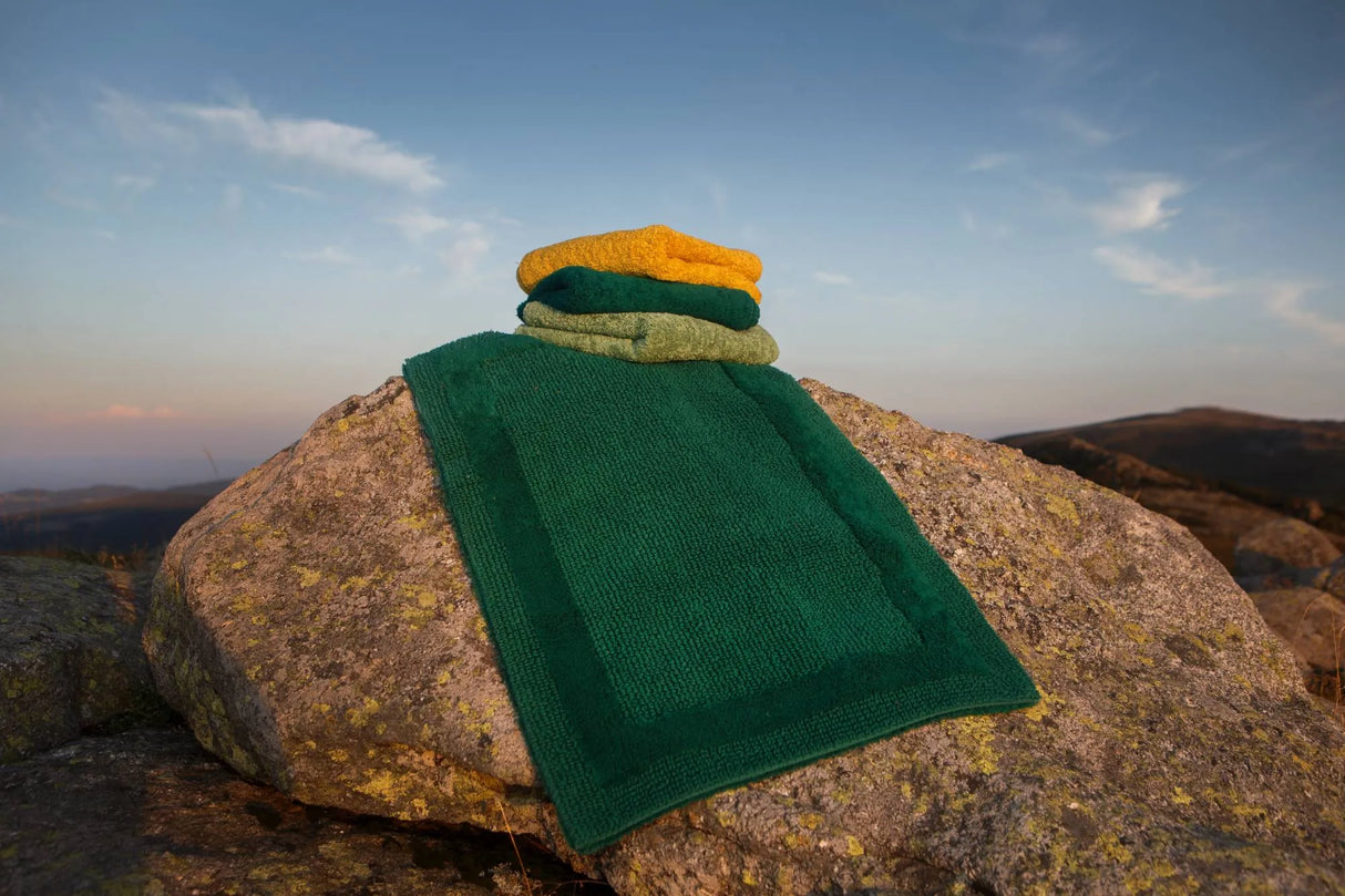 A&H Reversible Rug in 298 British Green. A&H Super Pile Towels, top-to-bottom in 870 Curcuma, 298 British Green and 165 Apple Green