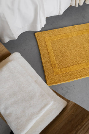 A&H Reversible Rug in 850 Safran. A&H Twill Towels in 103 Ivory