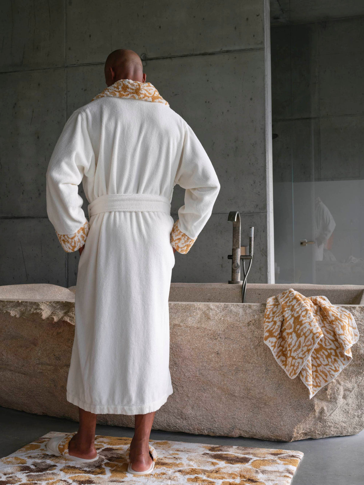 A&H Sauvage Towel in 840 Gold (edge of tub). A&H Sauvage Robe & Slippers in 840 Gold. A&H Gigi Rug in 840 Gold