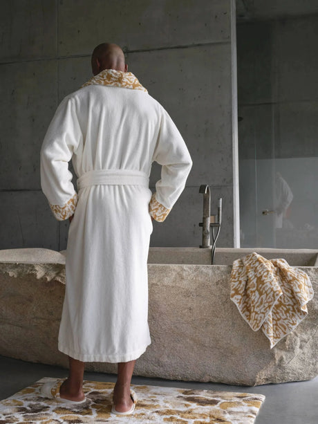 A&H Sauvage Towel in 840 Gold (edge of tub). A&H Sauvage Robe & Slippers in 840 Gold. A&H Gigi Rug in 840 Gold