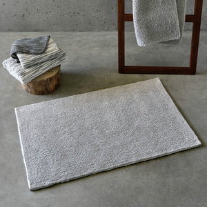 A&H Bay Bath Rug in 992 Platinum (bottom side shown on floor, top side hanging from ladder)